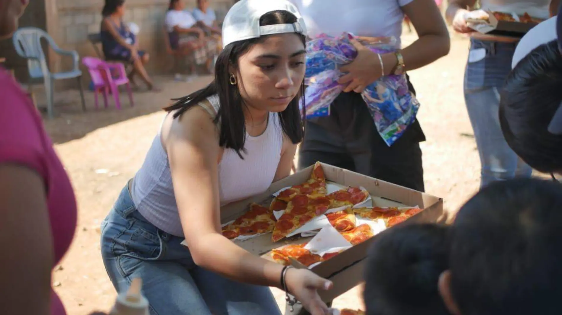 Mujer regalando pizza a los niños